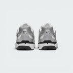 Focuses on the rear profile, highlighting the silver synthetic heel counter with ventilation perforations, micro-Swoosh logos, and the wide white-and-black foam stack below.
