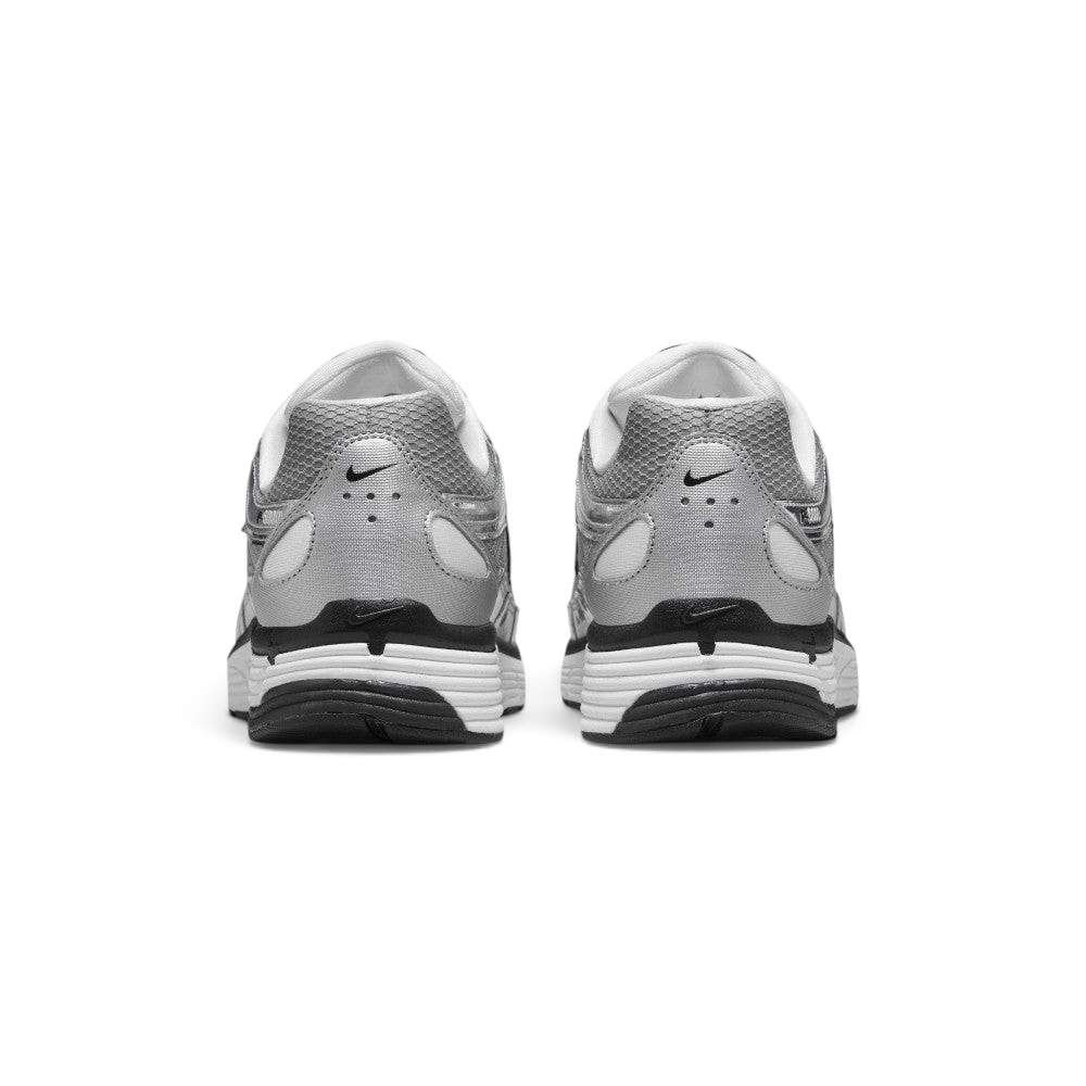 Focuses on the rear profile, highlighting the silver synthetic heel counter with ventilation perforations, micro-Swoosh logos, and the wide white-and-black foam stack below.