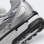 Highlights the "unreal" clean finish where the white foam midsole meets the black rubber outsole pods, displaying the translucent "P-6000" heel overlay badge and textured collar mesh.