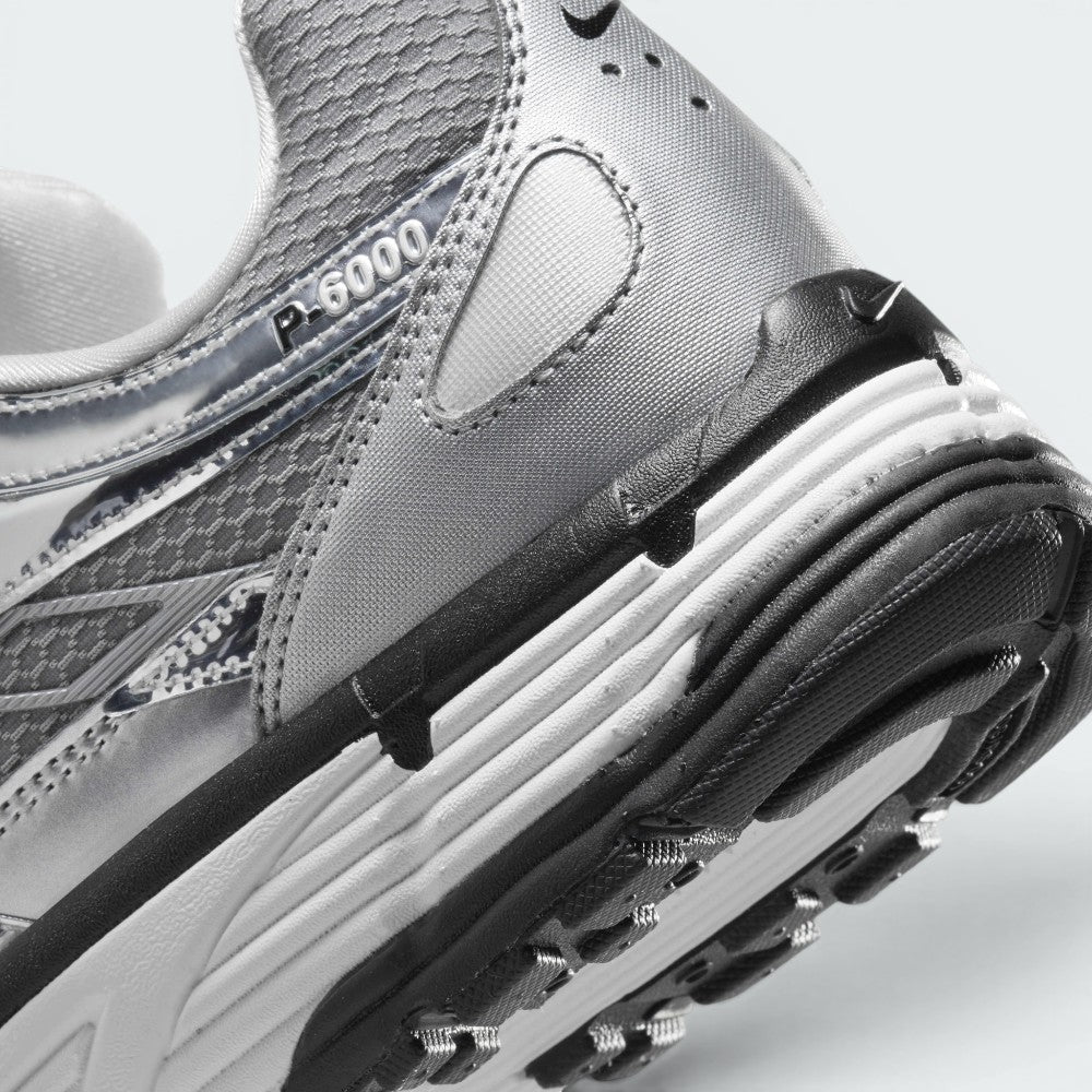 Highlights the "unreal" clean finish where the white foam midsole meets the black rubber outsole pods, displaying the translucent "P-6000" heel overlay badge and textured collar mesh.
