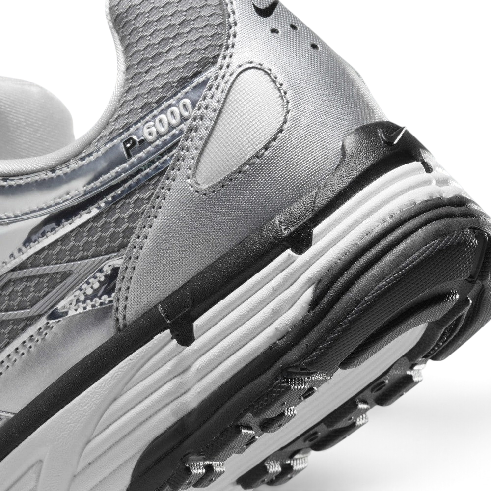 Highlights the "unreal" clean finish where the white foam midsole meets the black rubber outsole pods, displaying the translucent "P-6000" heel overlay badge and textured collar mesh.