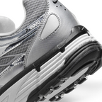 Highlights the "unreal" clean finish where the white foam midsole meets the black rubber outsole pods, displaying the translucent "P-6000" heel overlay badge and textured collar mesh.