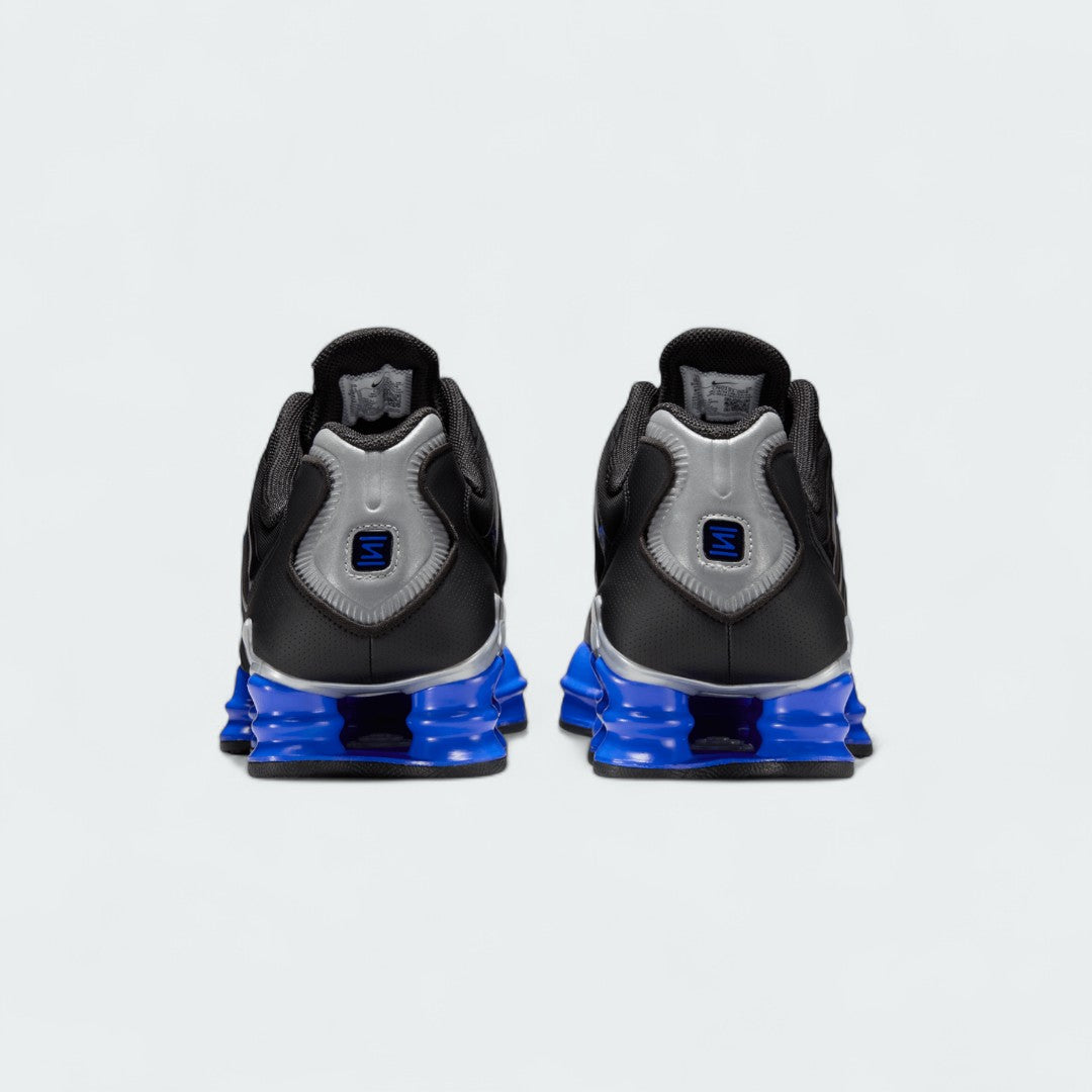 Rear view of the Nike Shox TL men's sneakers in black, focusing on the prominent Shox columns in the heel and the heel counter.