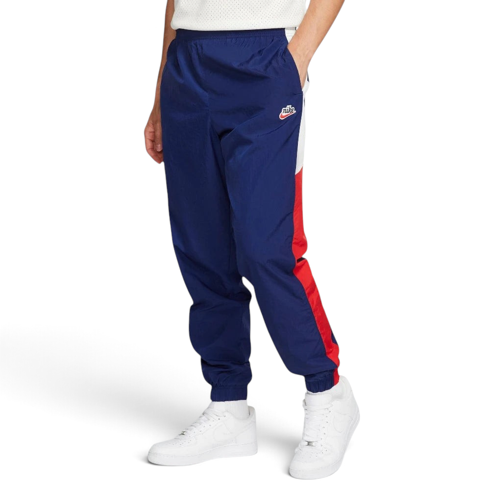 Highlights the high-velocity sweep of the Court Blue panelling tracking down the leg, showing the professional, matte texture of the Sail woven fabric and the clean integration of the zippered side pocket.