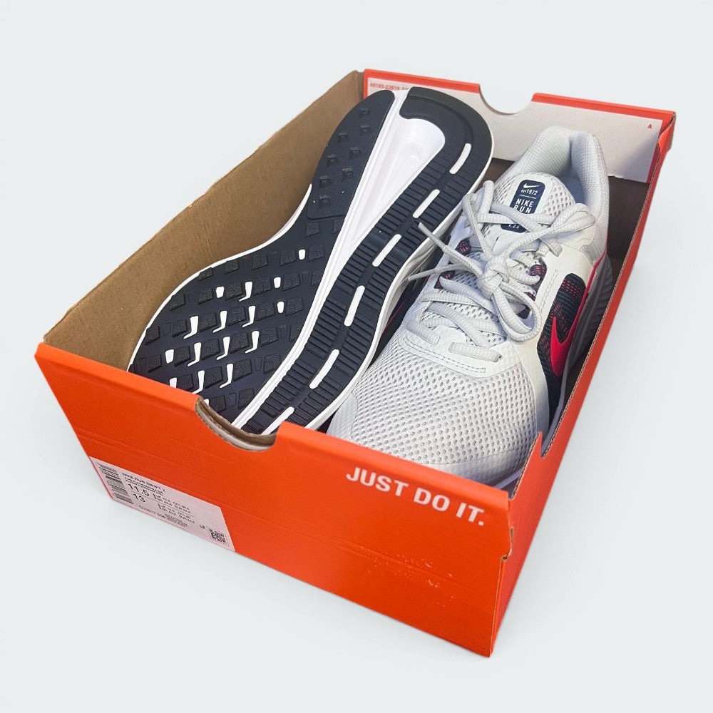 The Nike Run Swift 2 shoes sitting inside an open orange Nike shoebox with no lid, displaying the classic slogan "JUST DO IT." in white on the side of the box.