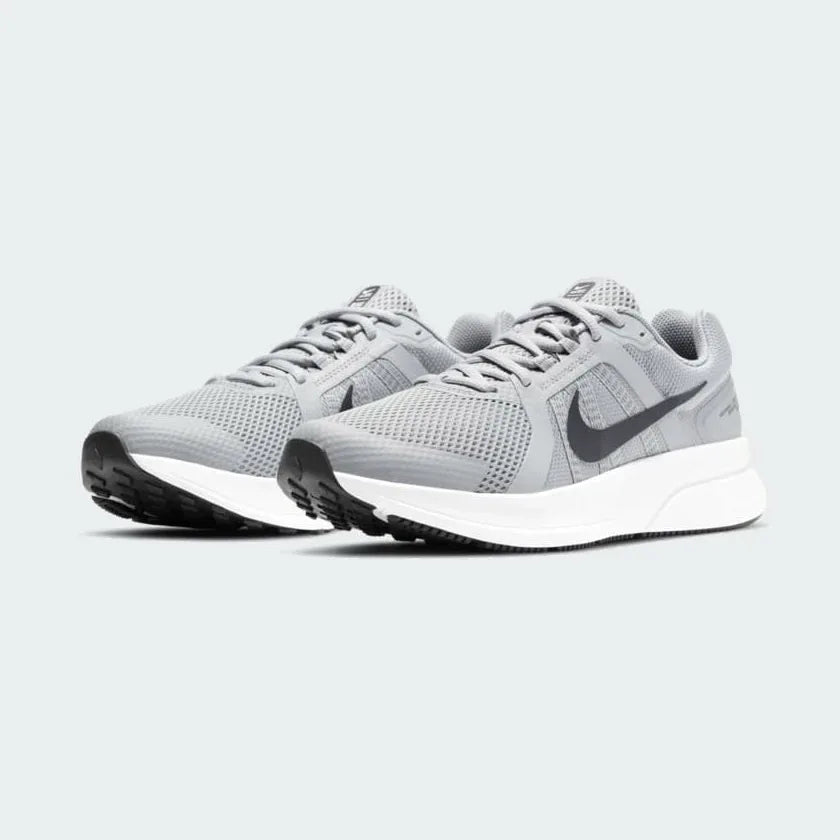 Angled view of two Nike Run Swift 2 Men's particle grey running shoes, side by side, showcasing their versatile design and cushioned profile.