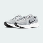 Angled view of two Nike Run Swift 2 Men's particle grey running shoes, side by side, showcasing their versatile design and cushioned profile.