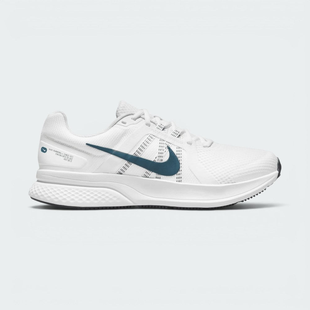 Highlights the lateral profile of the shoe, featuring a dark teal Swoosh sweeping across the Summit White mesh upper, dynamic midfoot webbing straps, white foam midsole, and a white heel overlay stamped with "NIKE RUNNING - SINCE 1972" graphic details.