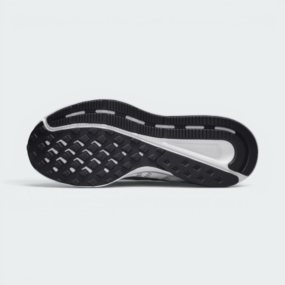 Displays the full-length black rubber outsole, showcasing the waffle-patterned forefoot tread pods, outer flex grooves, and central white stability channel exposing the foam carrier.
