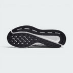 Displays the full-length black rubber outsole, showcasing the waffle-patterned forefoot tread pods, outer flex grooves, and central white stability channel exposing the foam carrier.