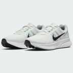 Emphasising the low-cut, athletic stance of the road runners, highlighting the contrast between the crisp white uppers, dark Swooshes, green midfoot strap accents, and green rubber outsole forefoot pods.