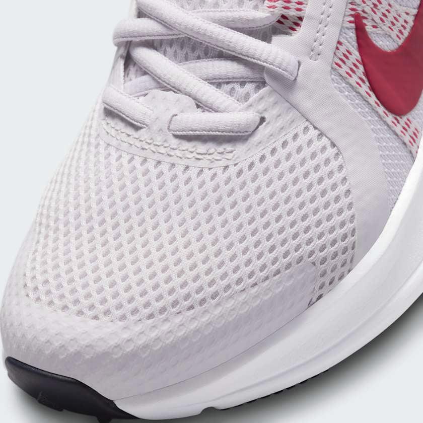 Close-up zoom on the front of the Nike Run Swift 2 Women's pink running shoes, showing the mesh upper texture, lacing system, and Flywire cables.