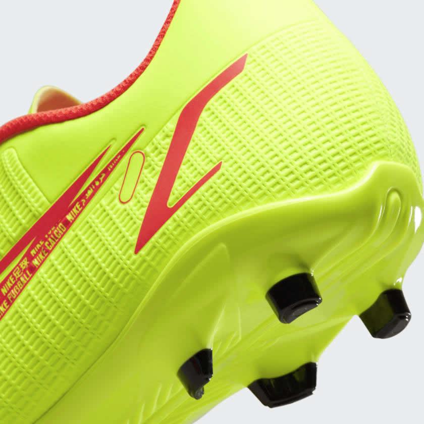 Detailed close-up of the Nike Mercurial Vapor 14 Club FG/MG football boot's outsole grip, conical studs, and heel counter.