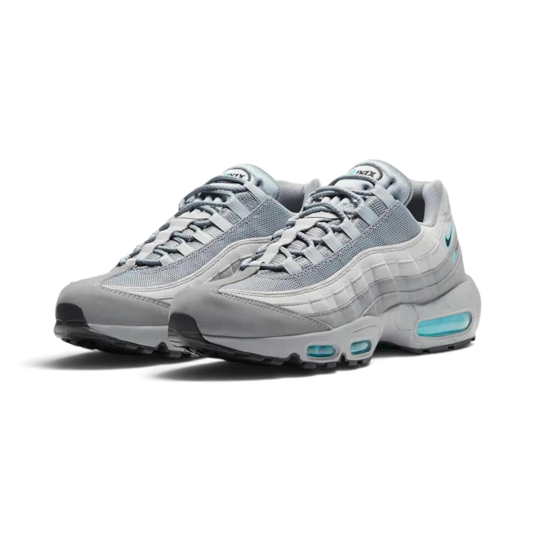 Angled view of two Nike Air Max 95 Men's running shoes in grey, blue, and black, side by side, showcasing their timeless design and layered upper.