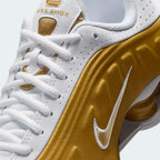 Close-up zoom on the front of the Nike Shox R4 Juniors' trainers, showing the synthetic overlays, lacing system, and perforated toe box.