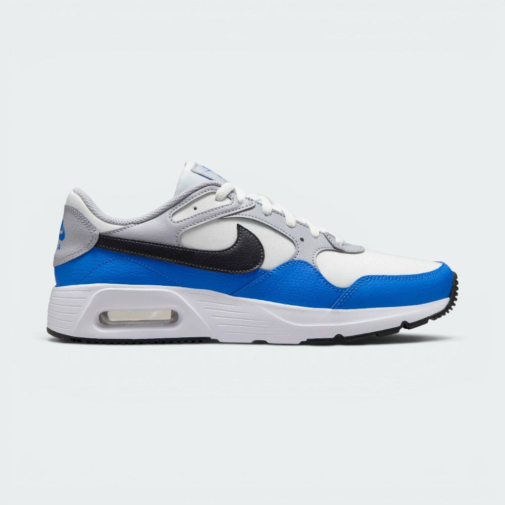Highlights the lateral profile of the shoe, featuring a sleek Anthracite black Nike Swoosh sweeping across the Summit White mesh quarter panel, vibrant Light Photo Blue leather mudguards, Wolf Grey upper eyelet overlays, and the visible Air window embedded in the white foam midsole. Main image