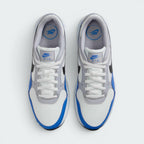 Focuses on the locked-in central lacing layout, displaying the clean symmetry of the white mesh tongue, matching white laces, grey eyestay panels, and blue "NIKE AIR" branding printed on the comfort insoles.
