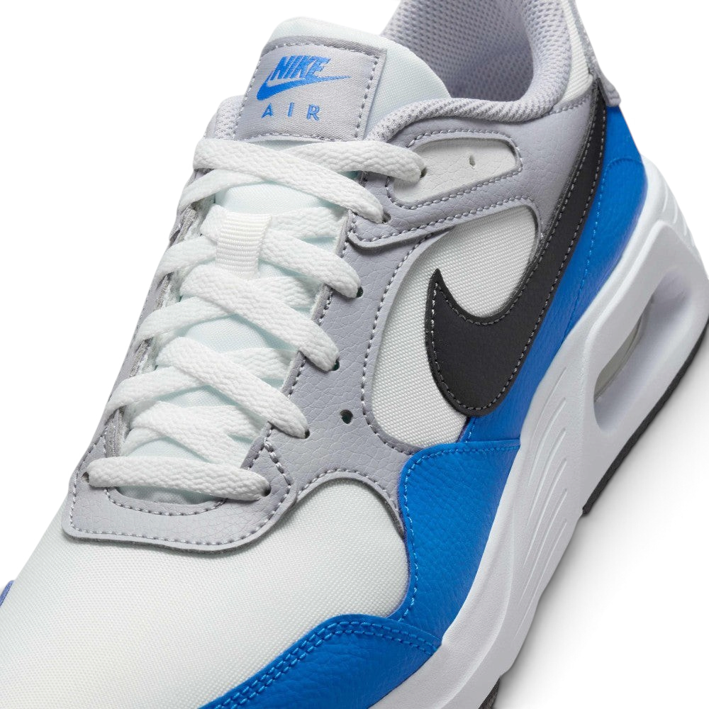 Details the micro-precision of the Summit White mesh toe box, showing the double-stitched Light Photo Blue leather toe mudguard and the neat tracking of the white laces across the grey tongue tag.