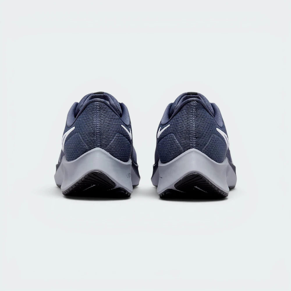 Focuses on the contoured shape of the tapered rear heel collar, highlighting the clean, structural sweep of the rear foam wedge built to relieve Achilles tendon pressure.