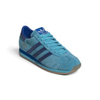 Angle View Showing Both Pair Side by Side: Angled front-three-quarter perspective of both shoes placed together, emphasizing the streamlined toe box shape and tonal blue suede texture.   