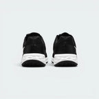 Focuses on the contoured shape of the padded low-cut collar, highlighting the smooth mesh heel panel and the wide, stable footprint of the cushioning foam sole unit below.