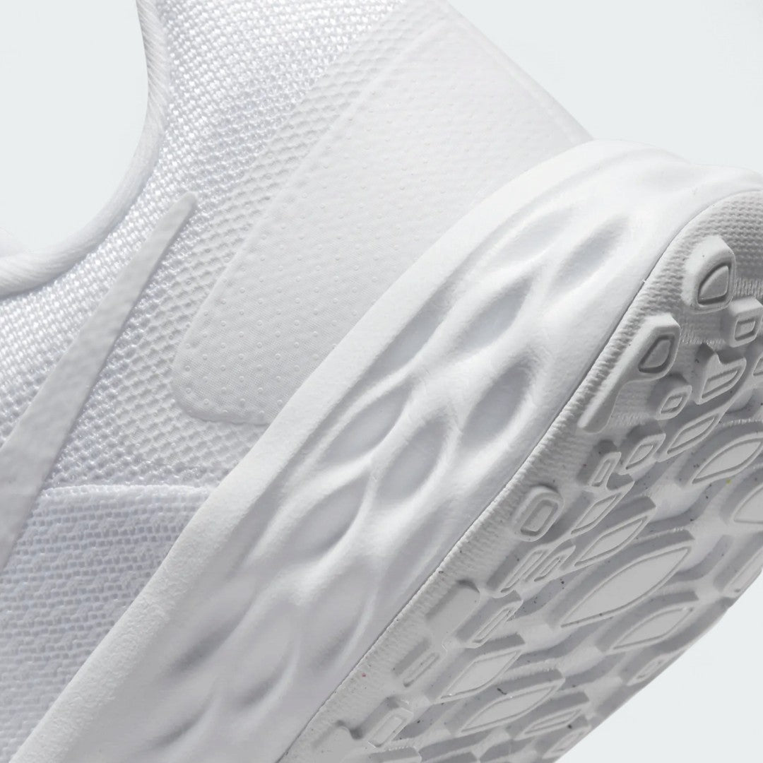 Detailed zoom on the outsole and midsole of the Nike Revolution 6 Women's white training shoes, highlighting the soft foam cushioning and durable rubber outsole.