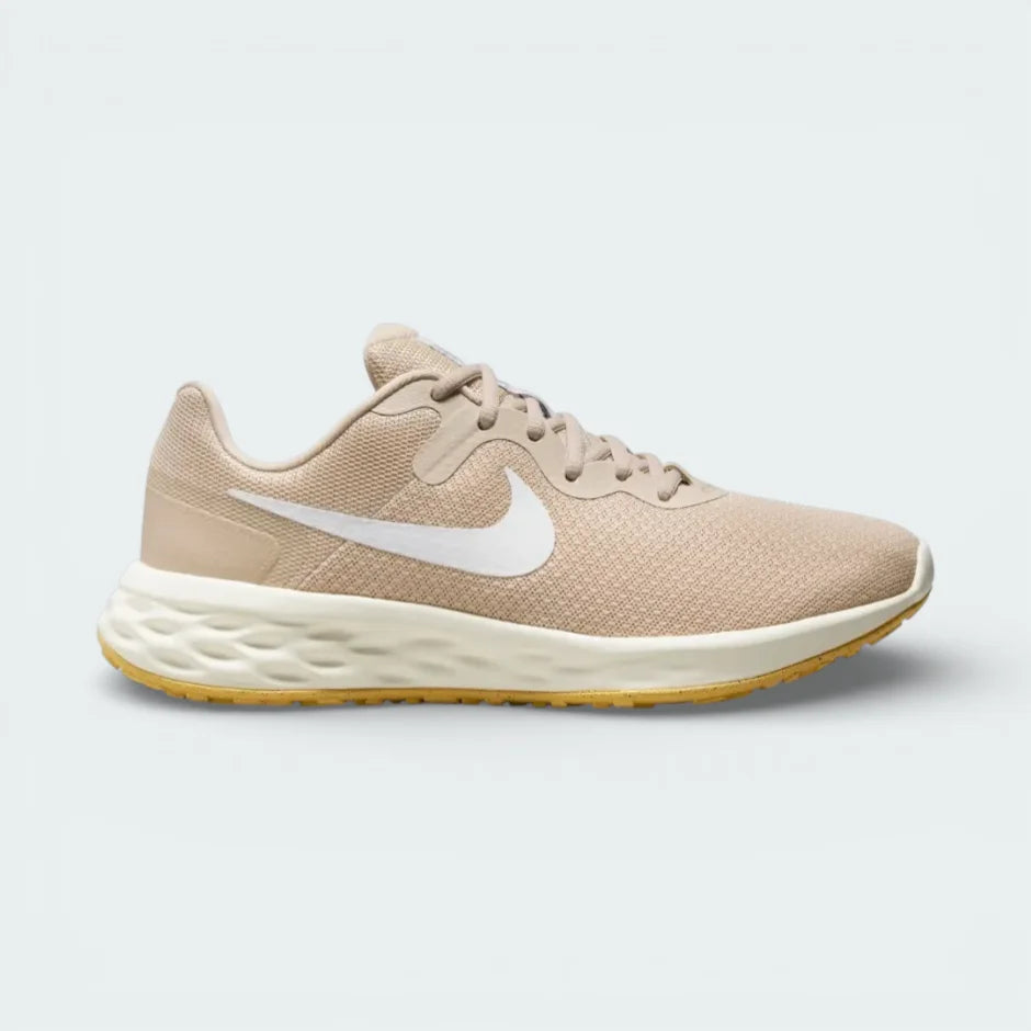 Side profile of the Nike Revolution 6 in Sand Drift, showing the white Swoosh, Topaz Gold accents, and the clean white foam midsole.