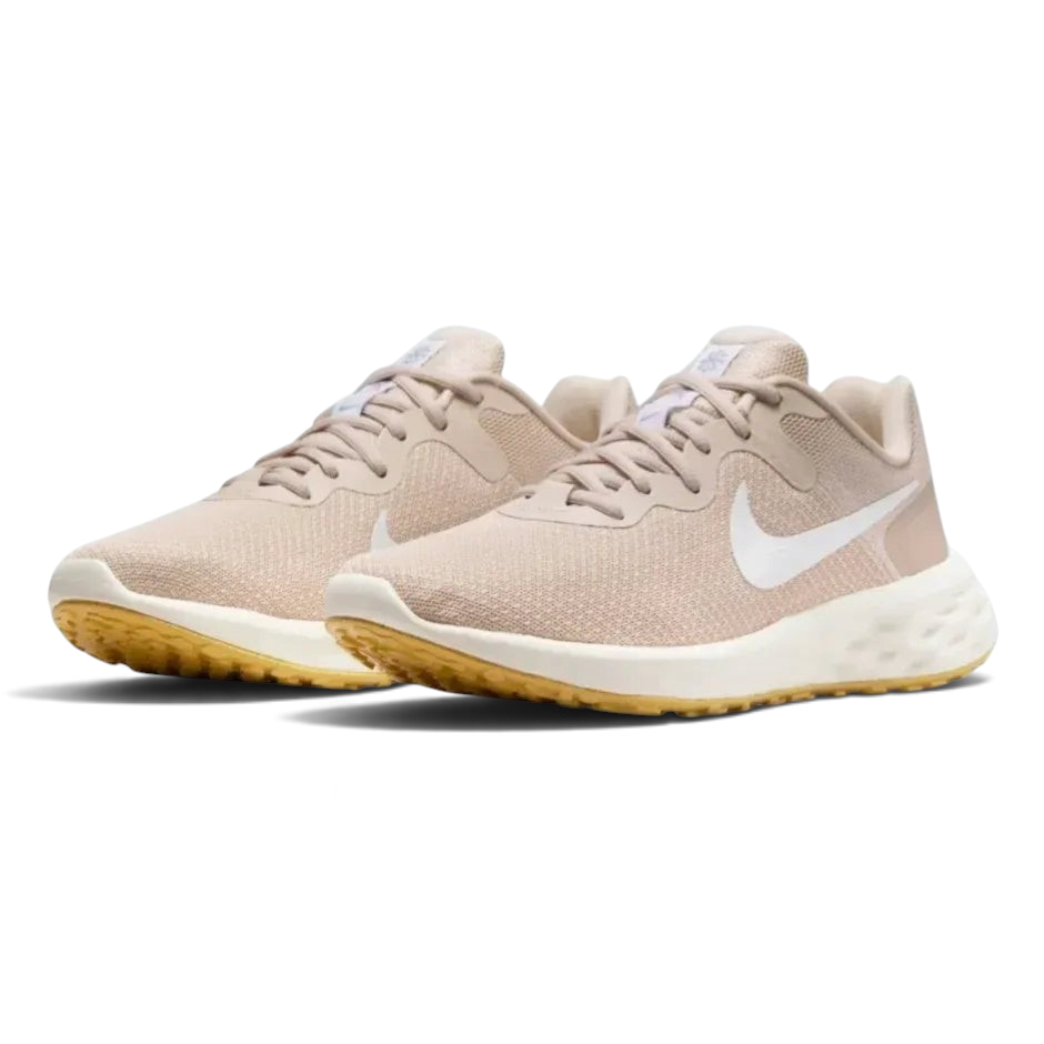 Angled shot of both Nike Revolution 6 trainers side by side, showcasing the sleek aerodynamic shape and warm tonal colourway.