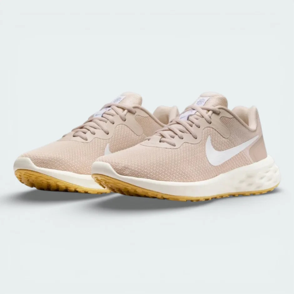 Angled shot of both Nike Revolution 6 trainers side by side, showcasing the sleek aerodynamic shape and warm tonal colourway.