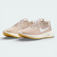 Angled shot of both Nike Revolution 6 trainers side by side, showcasing the sleek aerodynamic shape and warm tonal colourway.
