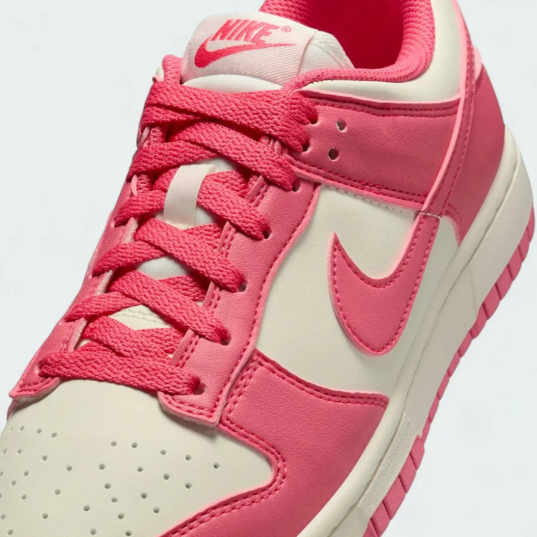 Close-up zoom on the front of the Nike Dunk Low Next Nature Women's pink trainers, showing the perforated toe box, lacing system, and texture of the upper materials.