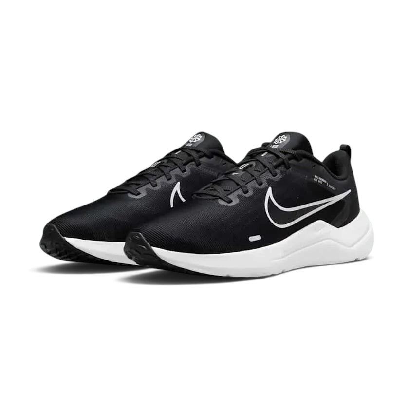 Angled view of two Nike Downshifter 12 Men's black and white training shoes, side by side, showcasing their versatile design and cushioned profile.