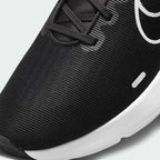 Close-up zoom on the front of the Nike Downshifter 12 Men's black training shoes, showing the mesh upper texture, lacing system, and supportive midfoot band.