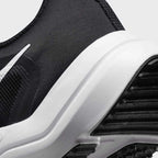 Detailed zoom on the outsole and midsole of the Nike Downshifter 12 Men's black training shoes, highlighting the soft foam cushioning and durable rubber outsole.