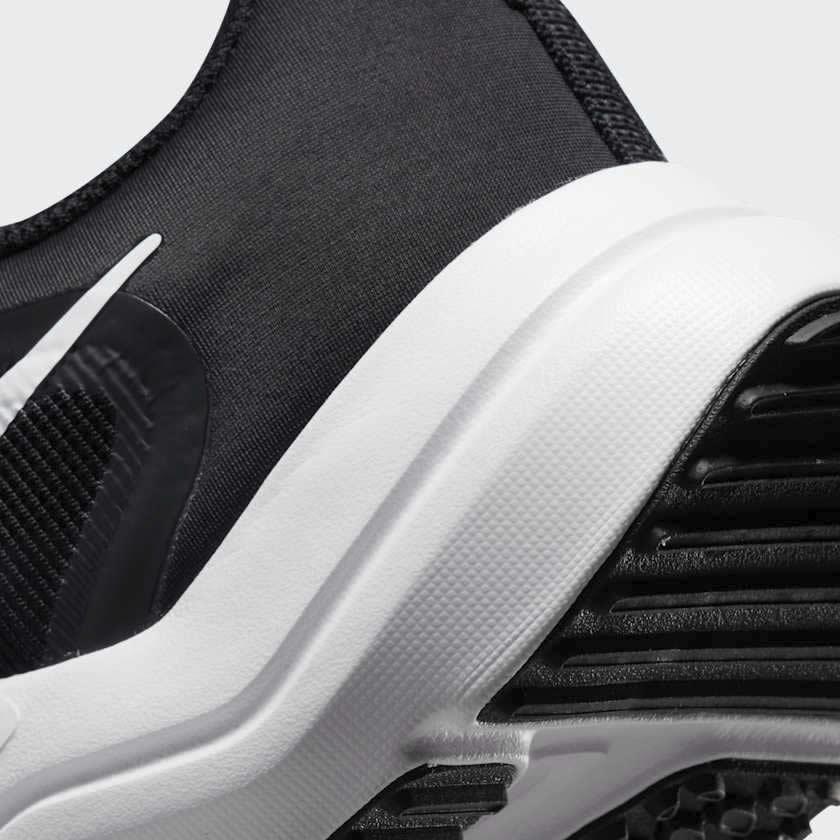 Detailed zoom on the outsole and midsole of the Nike Downshifter 12 Men's black training shoes, highlighting the soft foam cushioning and durable rubber outsole.