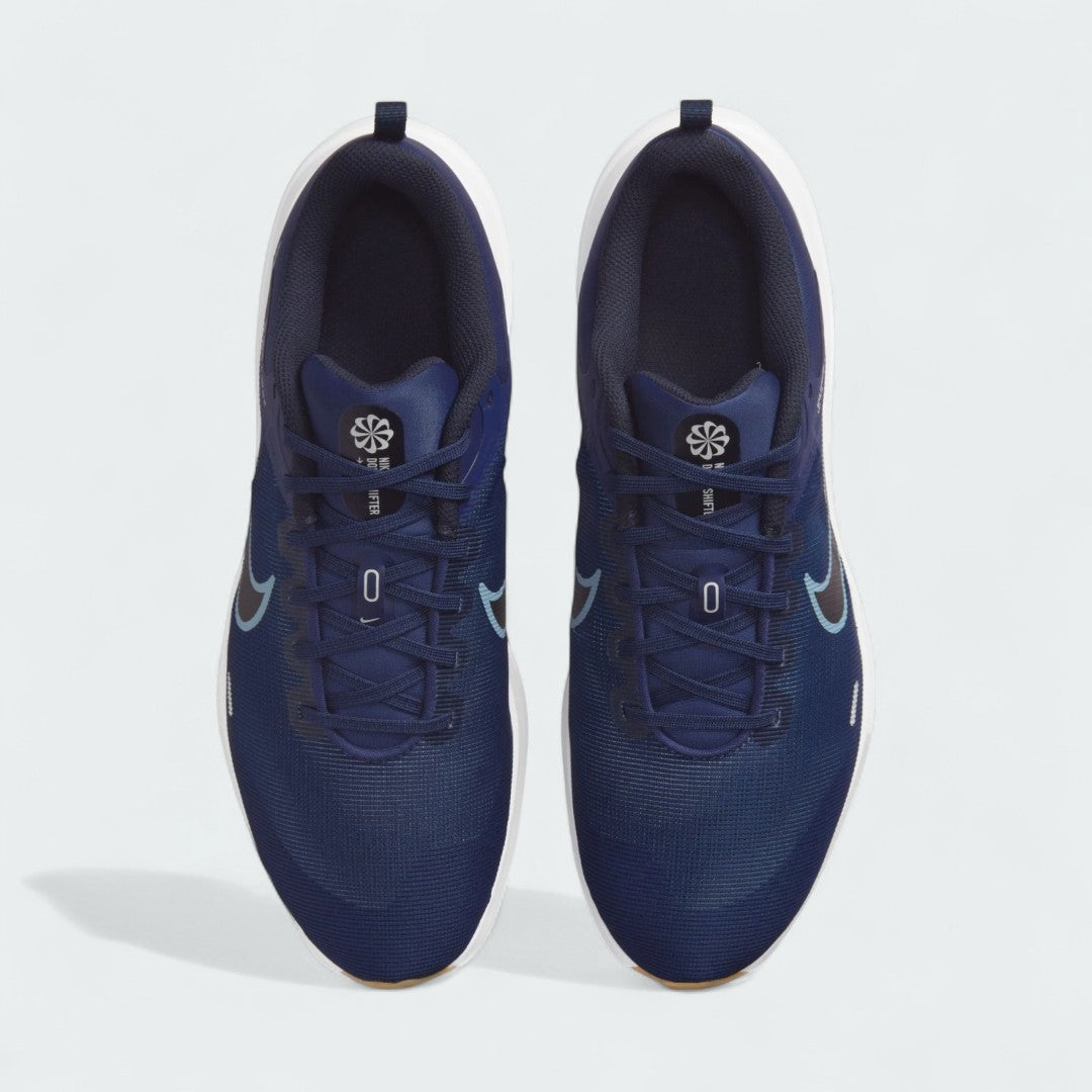 Top-down view of a pair of Nike Downshifter 12 Men's training shoes in navy blue, highlighting their streamlined silhouette and lace-up closure.