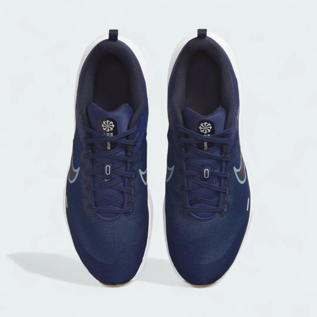 Top-down view of a pair of Nike Downshifter 12 Men's training shoes in navy blue, highlighting their streamlined silhouette and lace-up closure.