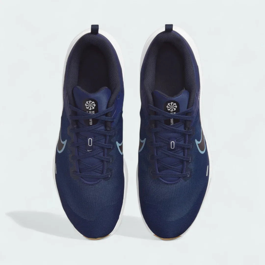 Top-down view of a pair of Nike Downshifter 12 Men's training shoes in navy blue, highlighting their streamlined silhouette and lace-up closure.