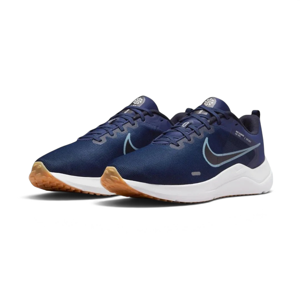 Angled view of two Nike Downshifter 12 Men's navy blue and white training shoes, side by side, showcasing their versatile design and cushioned profile.