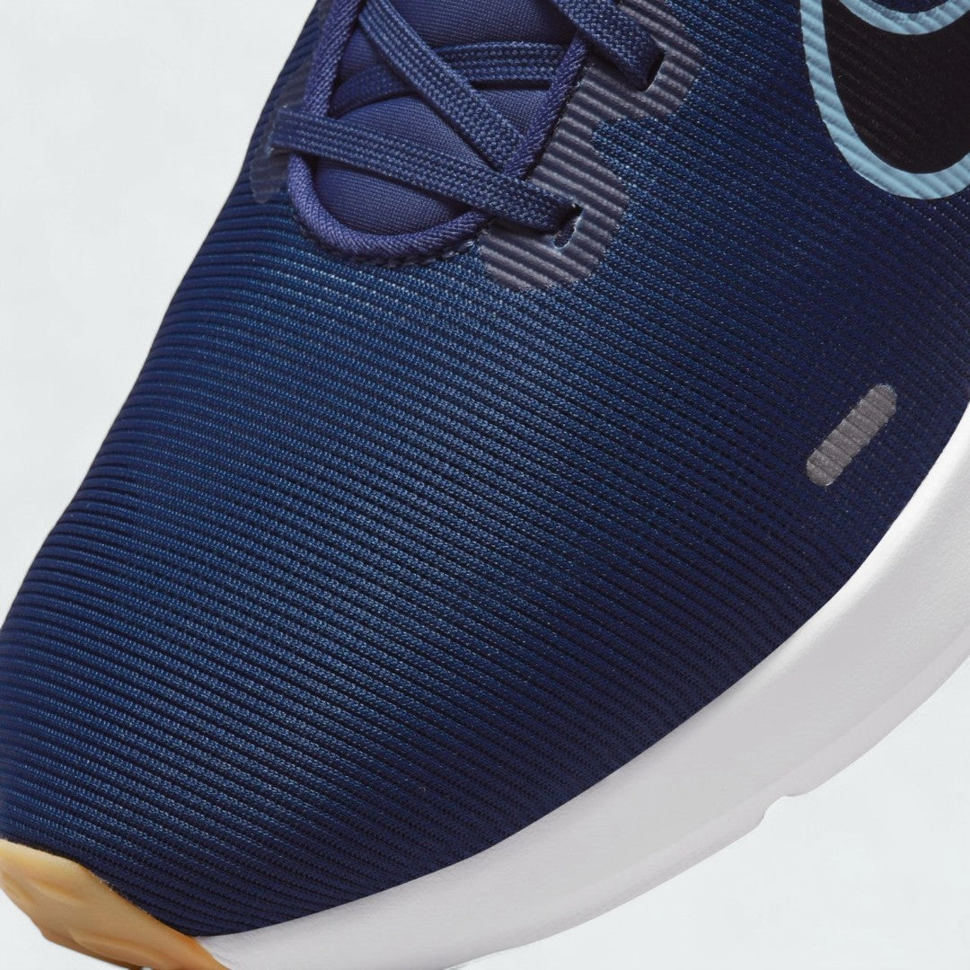 Close-up zoom on the front of the Nike Downshifter 12 Men's navy blue training shoes, showing the mesh upper texture, lacing system, and synthetic overlays.