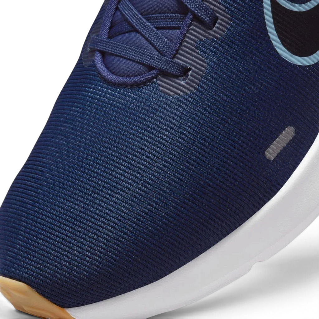 Close-up zoom on the front of the Nike Downshifter 12 Men's navy blue training shoes, showing the mesh upper texture, lacing system, and synthetic overlays.