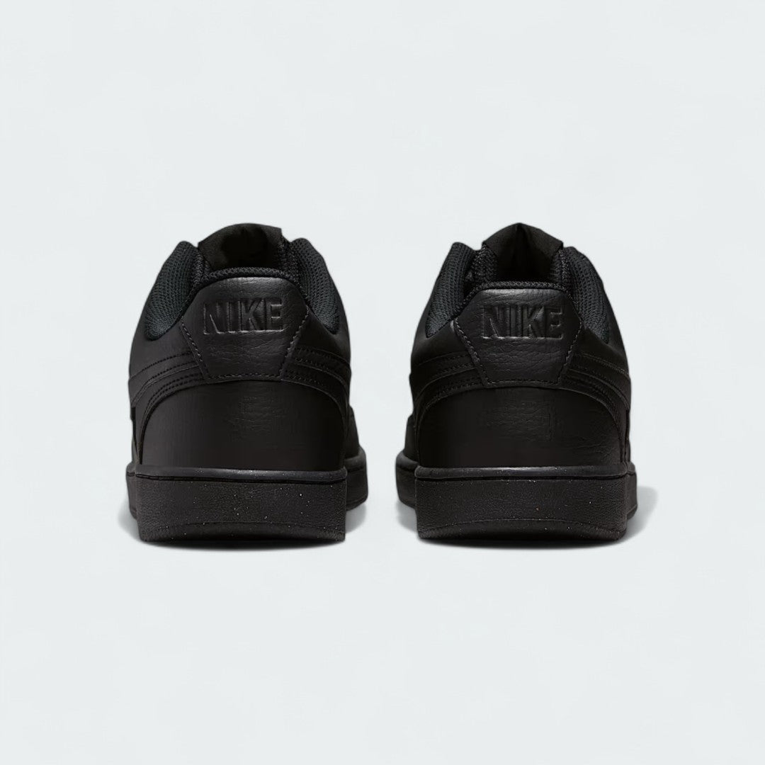 Rear view of the Nike Court Vision Lo Next Nature Men's black trainers, focusing on the heel panel and embossed Nike branding.