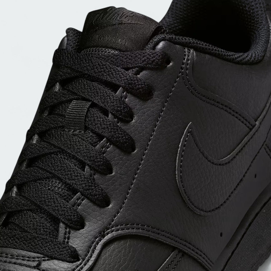 Close-up zoom on the front of the Nike Court Vision Lo Next Nature Men's black trainers, showing the perforated toe box, lacing system, and texture of the upper materials.