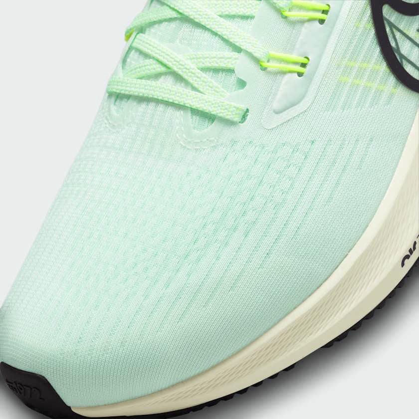 Close-up zoom on the front of the Nike Air Zoom Pegasus 39 Men's green running trainers, showing the breathable engineered mesh texture and integrated lacing system with Flywire cables.