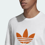 Close-up zoom on the Adidas Trefoil T-Shirt Men's in white, showing the soft cotton jersey fabric texture and the clear orange Trefoil logo print.