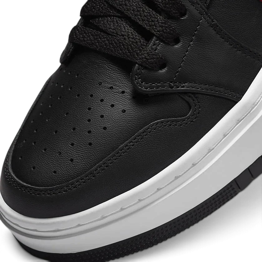 Close-up zoom on the front of the Air Jordan 1 Elevate Low Women's trainers, showing the perforated toe box, lacing system, and textured leather upper.
