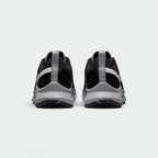 Focuses on the contoured shape of the raised heel collar, showcasing the robust pull loop and the structural sweep of the rear foam wedge built to absorb harsh trail impacts.