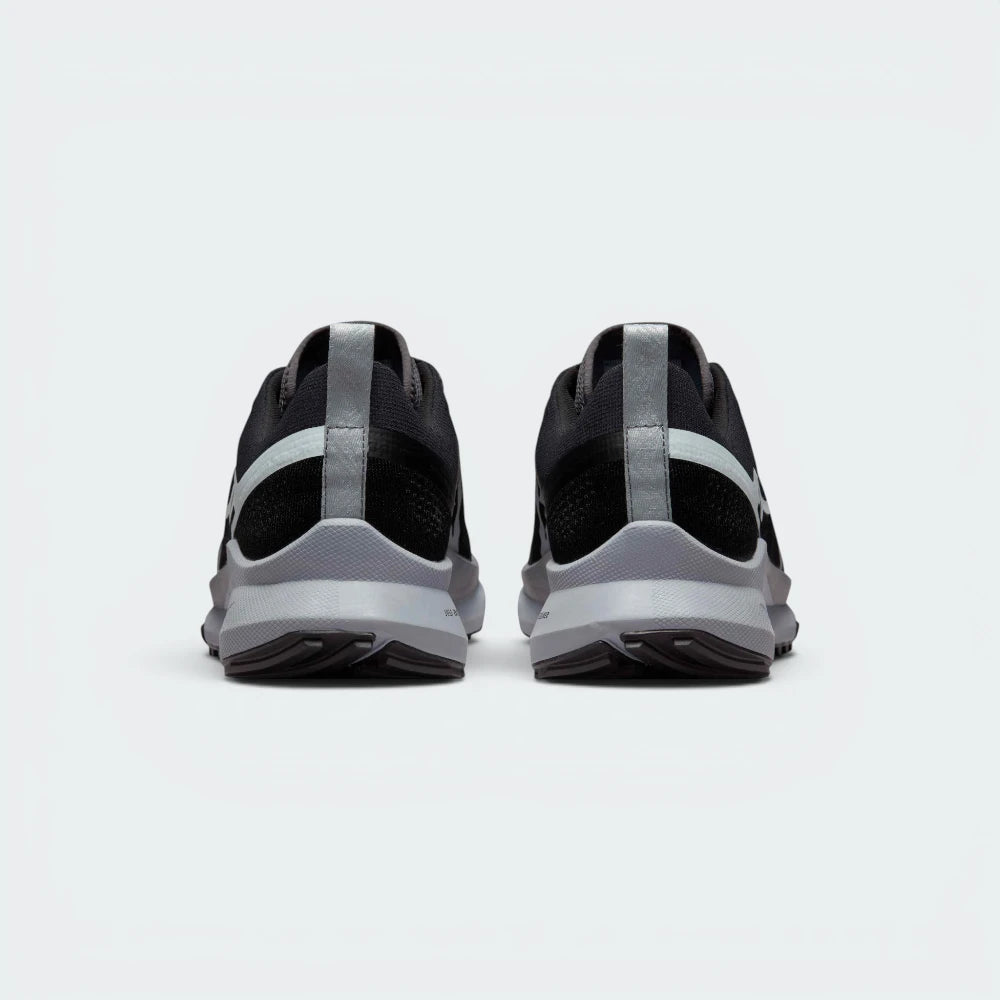 Focuses on the contoured shape of the raised heel collar, showcasing the robust pull loop and the structural sweep of the rear foam wedge built to absorb harsh trail impacts.