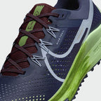 Close-up zoom on the front of the Nike React Pegasus Trail 4 Men's blue running shoes, showing the breathable mesh texture, lacing system, and protective toe overlay.