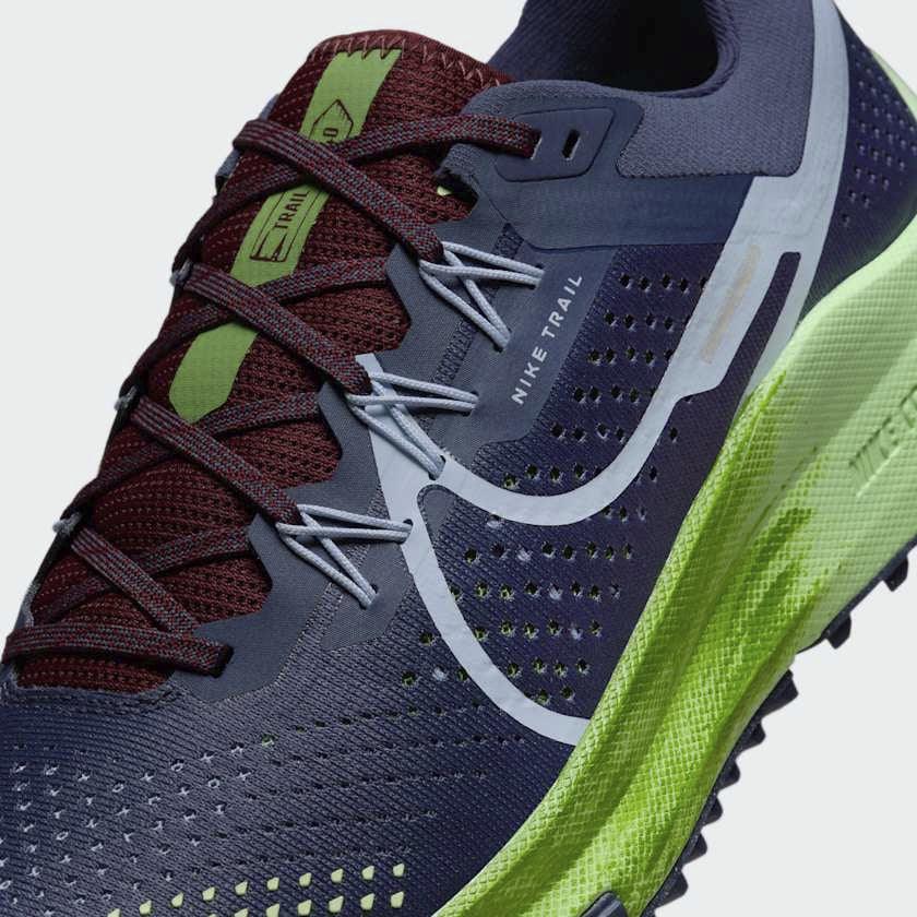 Close-up zoom on the front of the Nike React Pegasus Trail 4 Men's blue running shoes, showing the breathable mesh texture, lacing system, and protective toe overlay.